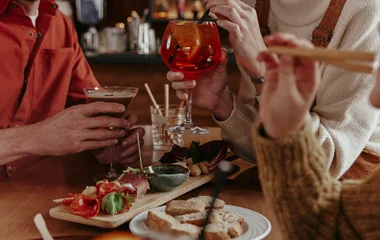 A man and a woman walking on a beach with palm trees