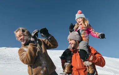 Famille qui joue dans la neige