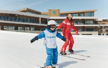 moniteur esf et un enfant descendant une piste à ski