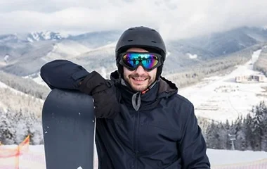 A relaxed snowboarder enjoying the thrill of snowboarding at Club Med’s resort