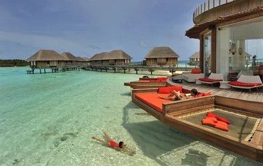 A imagem apresenta as vilas ecológicas do Resorts All-Inclusive do Club Med no oceano índico. São cabanas construídas sobre as águas cristalinas do oceano.