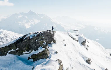at the top of a peak skiing