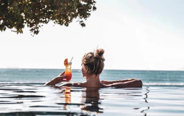 Woman drinking a cocktail by the pool in Mauritius