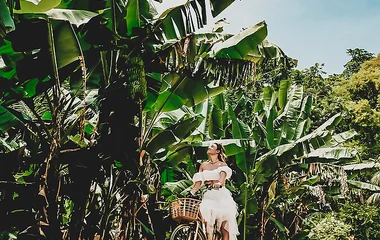 Ragazza in bicicletta sulle strade panoramiche delle Seychelles con paesaggio tropicale sullo sfondo
