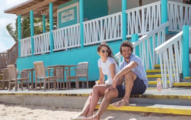Paar sitzt auf den Treppen einer Strandbar