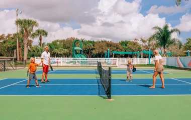 Familie spielt gemeinsam Tennis