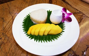 Dolce tradizionale thailandese Khao Niao Mamuang servito in porzione singola con guarnizione colorata