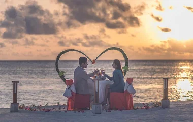 A couple enjoying a drink by the sea