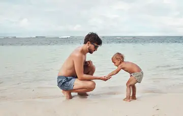 parent with a child on the beach