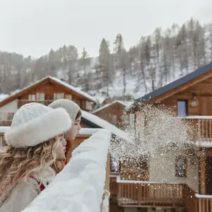Due bambini giocano soffiando sulla neve in una vacanza Club Med in famiglia