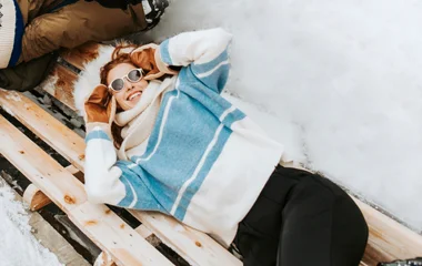Girl lying on the bench in the snow