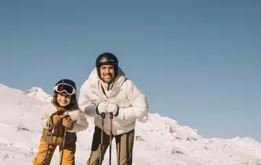 child and father skiing