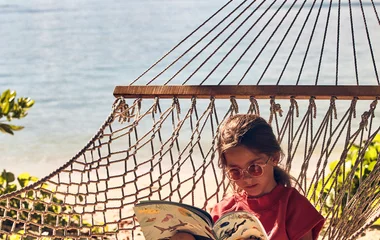 Girl on a hammoc reading book