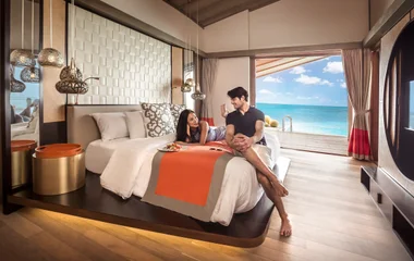 Couple in the bed at Finolhu overwater villas
