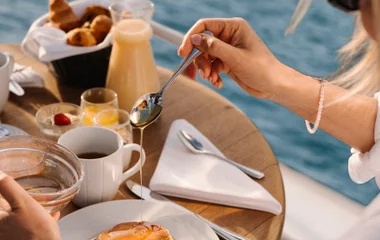 Mujer poniendo miel en panqueques de desayuno.