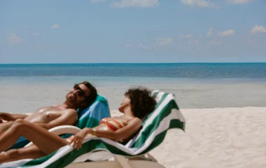 casal na praia compartilhando fones de ouvido