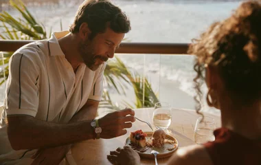 Casal sentado na mesa para almoço em resort all inclusive no Caribe