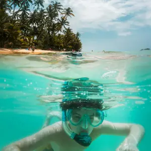 a kid snorkelling near a tropical beach