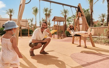 a child and a GO playing in front of a swing