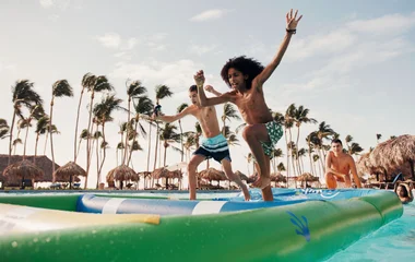 Teens having fun on an inflatable structure at the pool