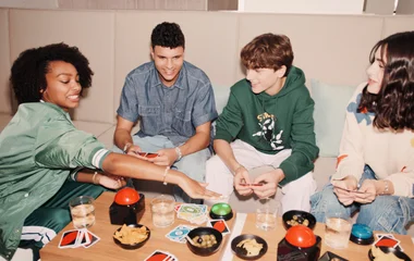 Teens playing card games together around a table