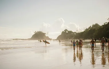 A picture of a beach in Byron Bay, with its many surfers.