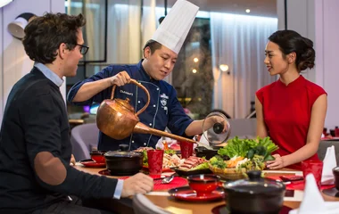 Casal em jantar gourmet sendo servidos pelo chef