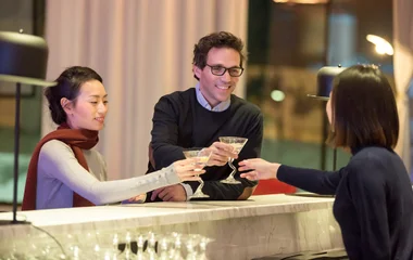 Casal recebendo drinks da bartender