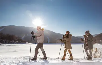 Três amigos caminhando na neve.