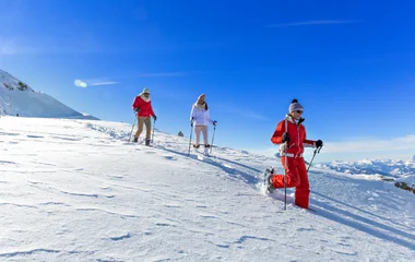 Duas pessoas e um instrutor fazendo caminhada com raquete.