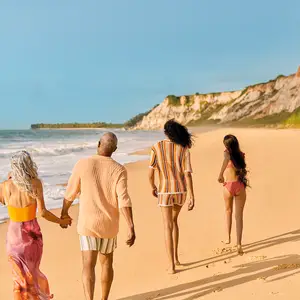 Família caminhando entre a praia e as falésias de Trancoso