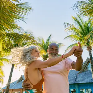 casal feliz sentados à mesa na praia