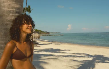 Hóspede apoiada em palmeira de uma das praias da República Dominicana
