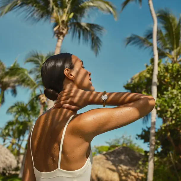 mulher pegando sol e a sombra de uma palmeira