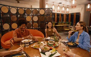 Grupo de amigos confraternizando na mesa de jantar