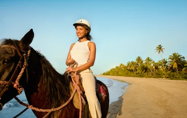 Mulher fazendo um passeio a cavalo.