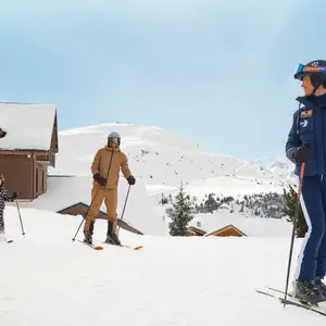 Criança e seus pais em aula de esqui em Alpe d’Huez.