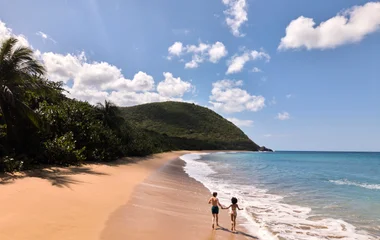 Casal correndo na praia.