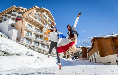 Pareja saltando frente al Club Med Val Thorens.