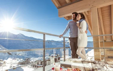 Pareja admirando el paisaje nevado desde el resort.