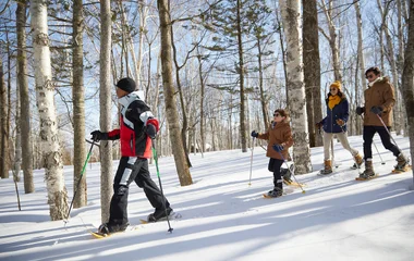 People walking in snow with equipments.
