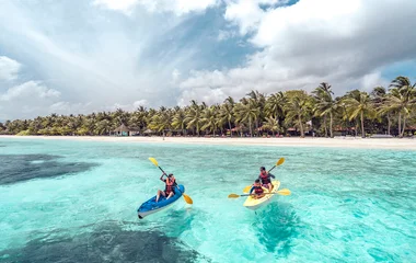 Family kayaking in turquoise waters.