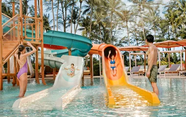Family enjoying water park slides.