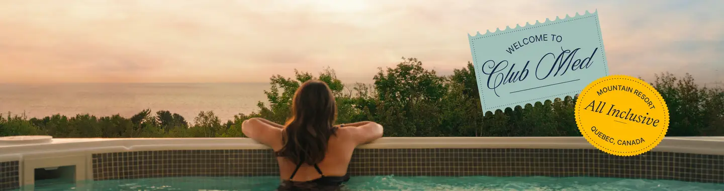 A woman seen from behind in a jacuzzi in front of the sunset