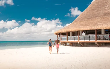 Pareja caminando por la playa.