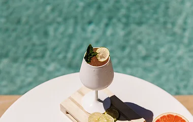 Mesa con bebida y gafas de sol.