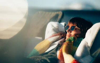 Mujer con anteojos de sol tomando sol.