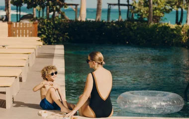 Mujer e hijo junto a la piscina.
